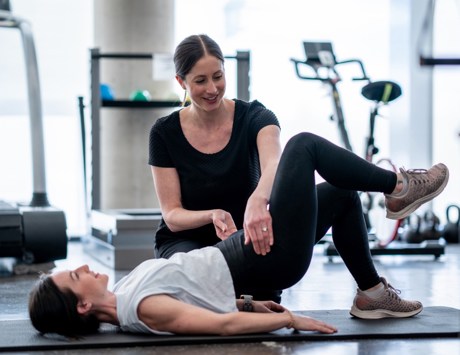 Physiotherapist helping women doing exercise
